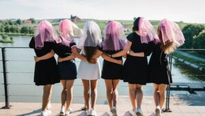 Bride,And,Bridesmaids,Stands,Back,On,A,Beach,And,Celebrating